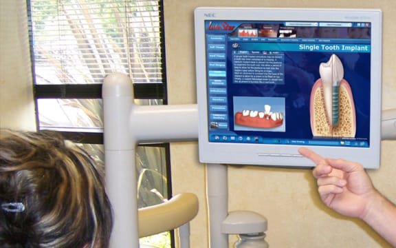 A dentist using Dental SideKick to explain a single-tooth implant chairside