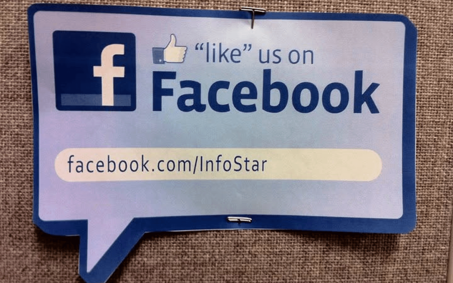 Facebook sign reading ‘like us on Facebook,’ with the address facebook.com/InfoStar.
